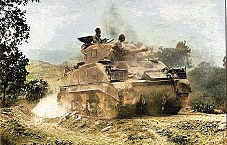 Warwickshire Yeomanry Tank in Italy A military tank driving through a rugged, dusty landscape.
